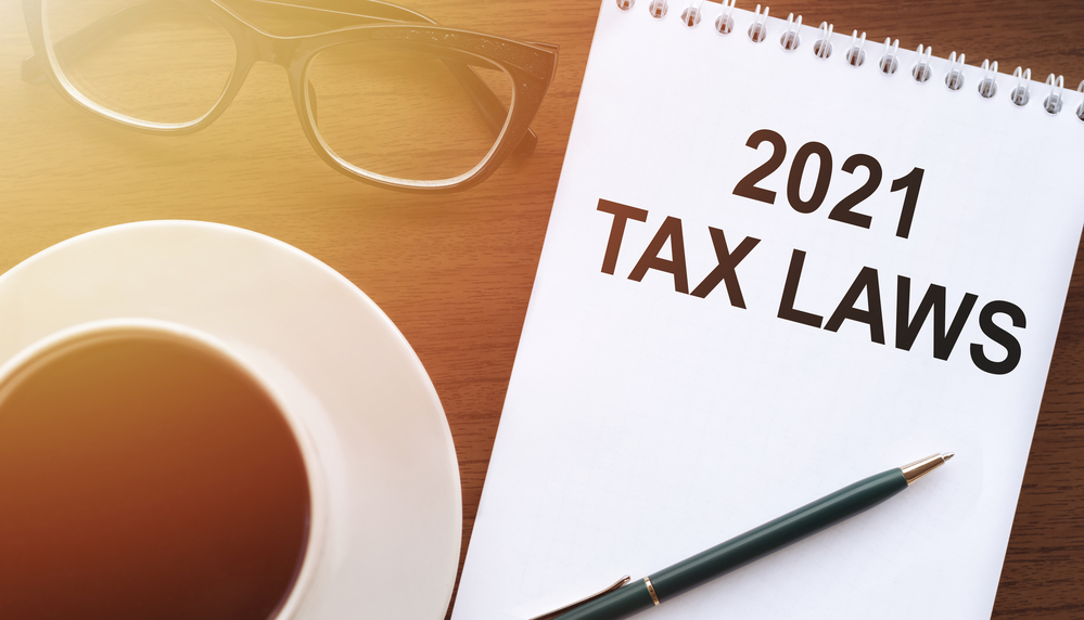 2021 tax laws written on notepad near pen and glasses