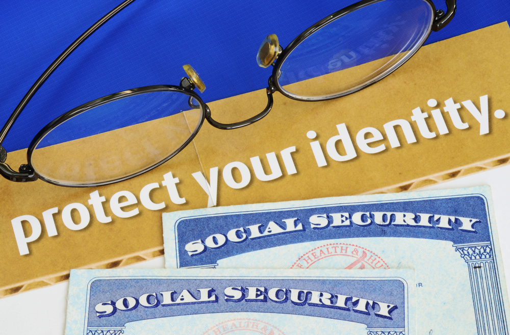 Social Security cards and glasses on top of paper reading "protect your identity"