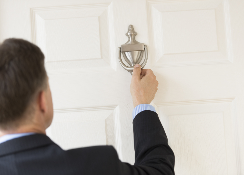 Businessman using door knocker