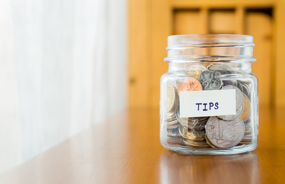 Tip jar full of coins on counter