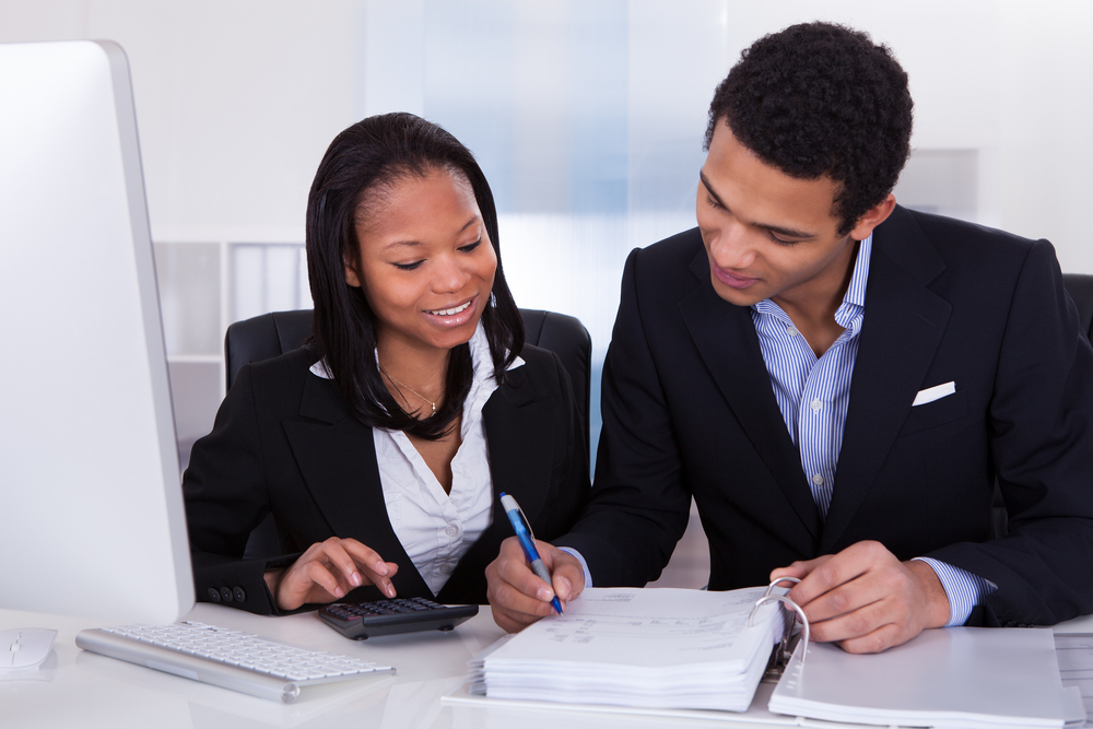 Two professionals consulting over financial documents