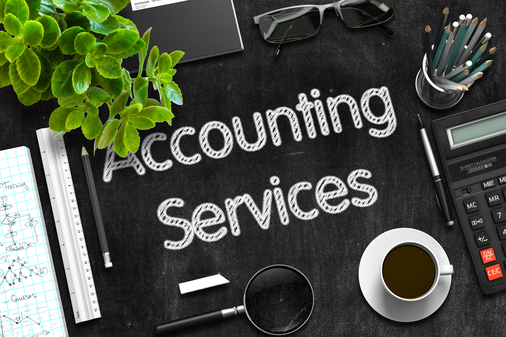 Accounting services on black chalkboard with bookkeeping tools