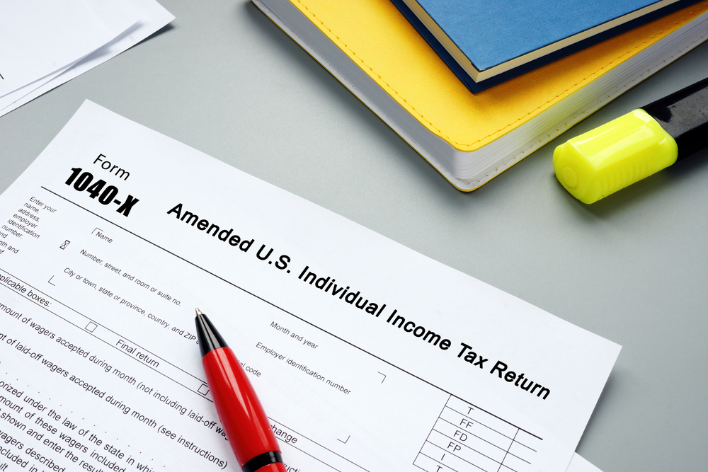 Tax form 1040-X on desk with pen and office supplies