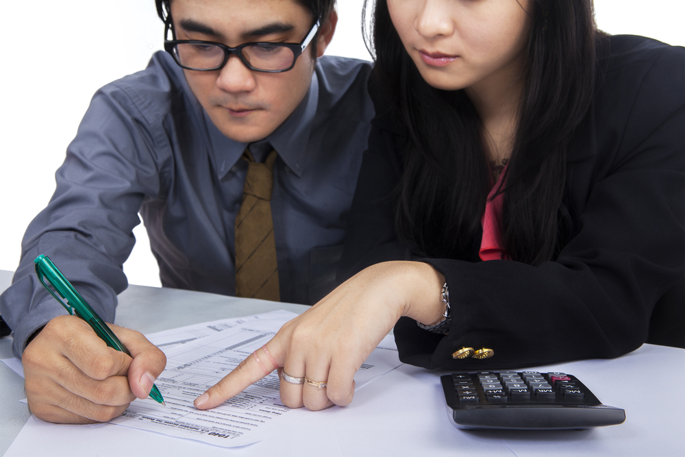 Man and woman in business attire looking at forms