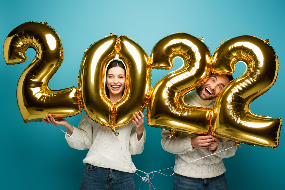 Couple smiling with golden 2022 balloons