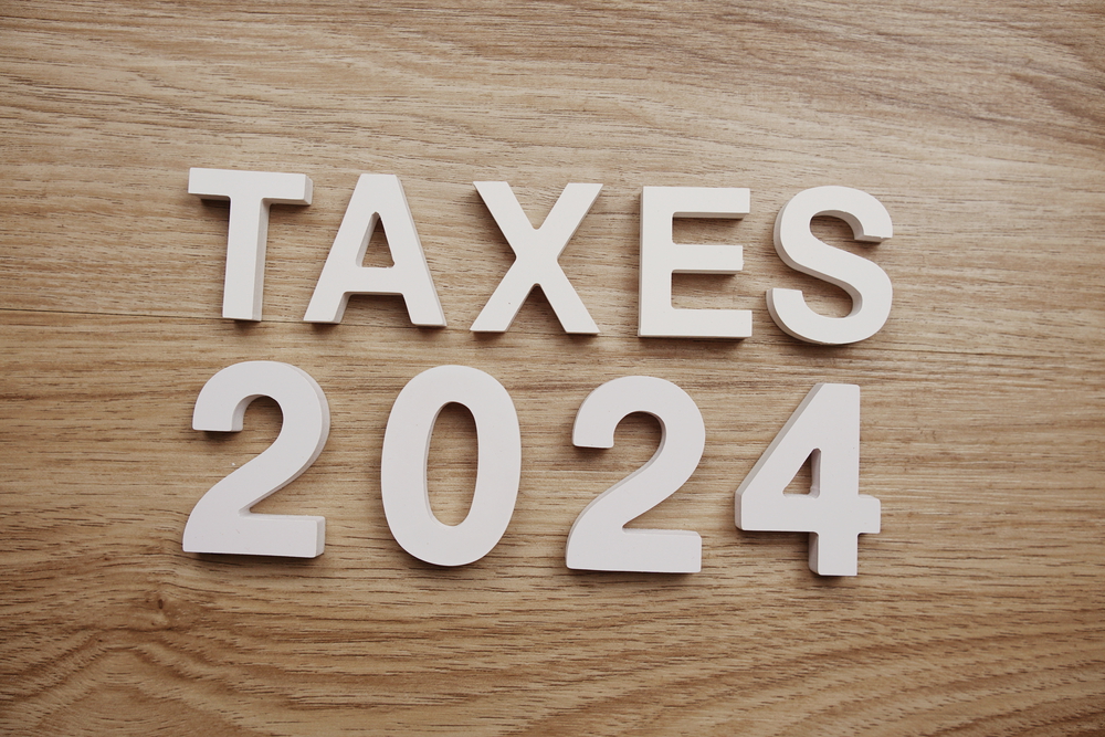 Wood letters saying Taxes 2024 on wood desktop