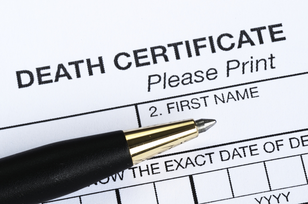 Death certificate with pen resting on top