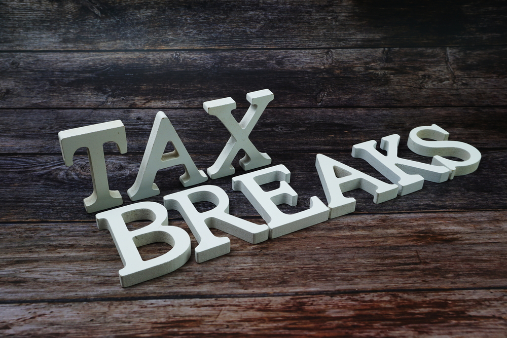Words "tax breaks" written on wooden background