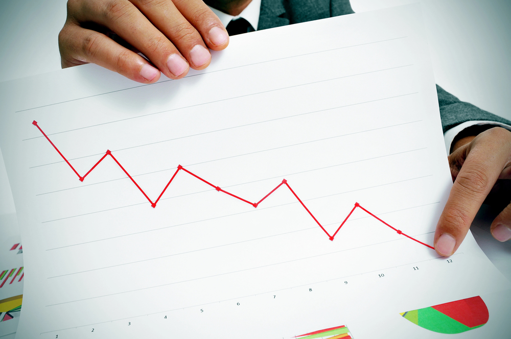 Business man holding chart that shows economic loss