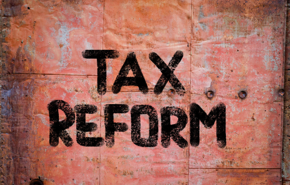 Tax Reform in large, black letters on rusted metal backdrop