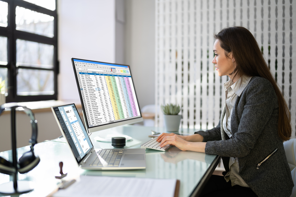 Woman looking at invoice and spreadsheet on computer