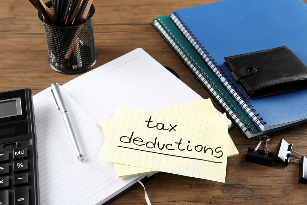 "Tax deductions" written on sticky note on top of office supplies